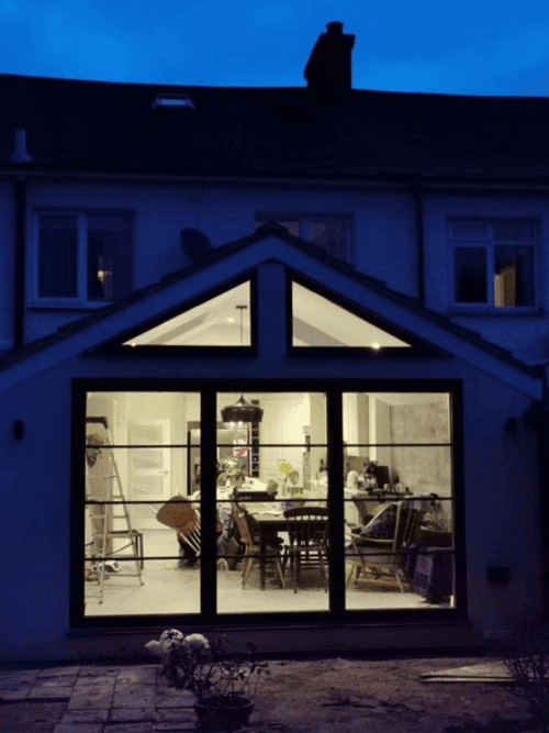 Rear house extension featuring sliding glass doors.