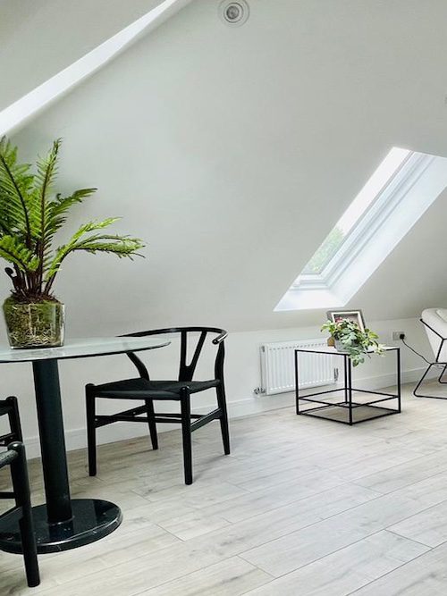 Open-plan attic kitchen and dining area in Surrey with modern fixtures.